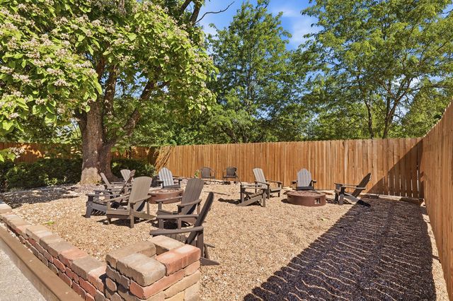 Fire-pit courtyard under the catalpa, fenced service yard beyond