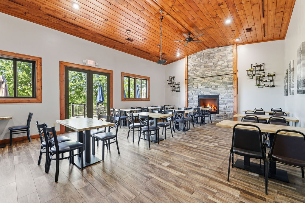 Original photograph: Dining room toward the fireplace, windows to the north deck. Digitally altered: fire added