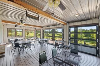 Enclosed porch with glass overhead doors, ceiling fans and radiant heaters
