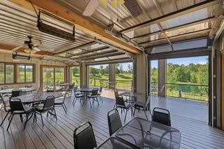 Enclosed porch open to the deck, pond beyond