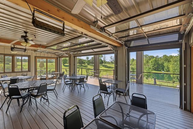 Enclosed porch open to the deck, pond beyond