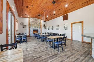 Dining room with cathedral pine ceiling and stone fireplace. Digitally altered: fire added